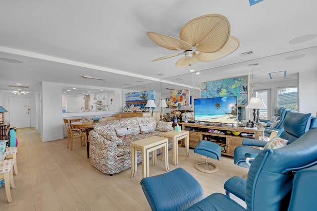 living area featuring light wood-style floors, ceiling fan, and visible vents