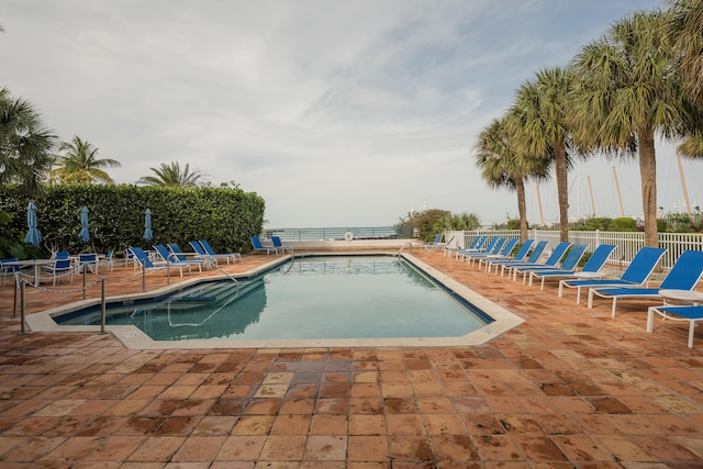 pool with a patio and fence