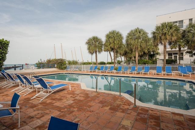 pool with fence and a patio