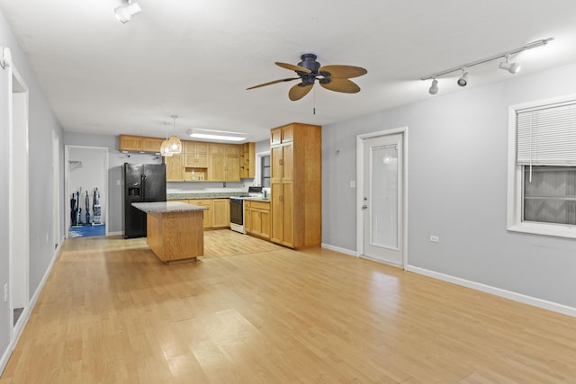 kitchen with pendant lighting, white range with gas stovetop, light hardwood / wood-style floors, a kitchen island, and black refrigerator with ice dispenser