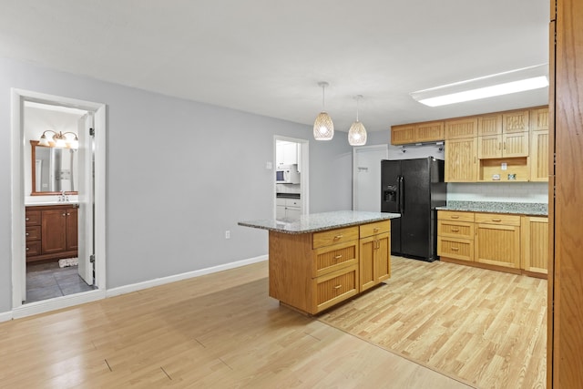 kitchen with a center island, light hardwood / wood-style flooring, black fridge with ice dispenser, and decorative light fixtures