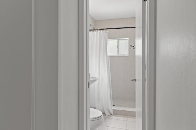 bathroom with tile patterned flooring, curtained shower, and toilet