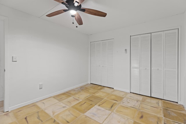 unfurnished bedroom featuring multiple closets and ceiling fan