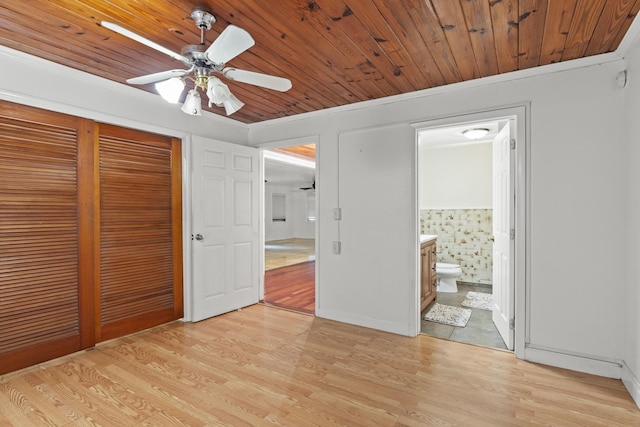 unfurnished bedroom with crown molding, wood ceiling, light hardwood / wood-style flooring, and a closet