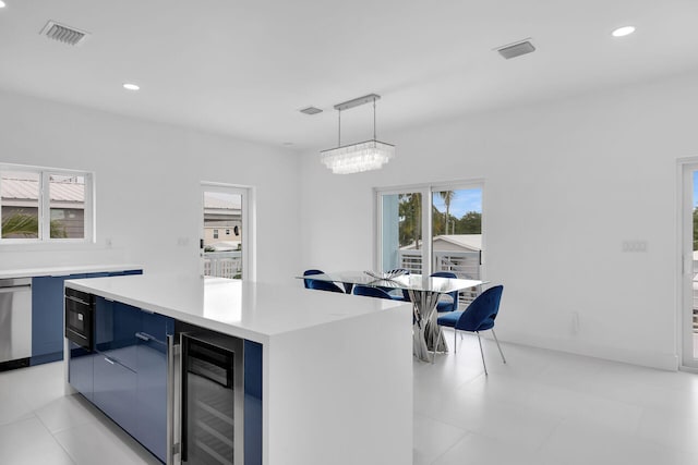 kitchen with a center island, pendant lighting, beverage cooler, and an inviting chandelier