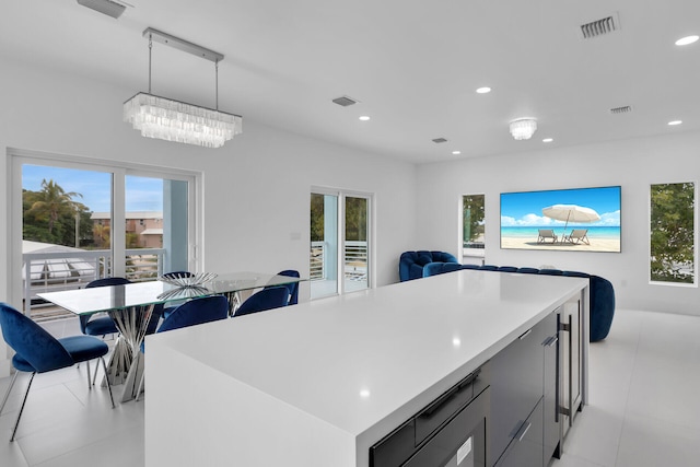 kitchen with a healthy amount of sunlight, decorative light fixtures, gray cabinets, and a kitchen island