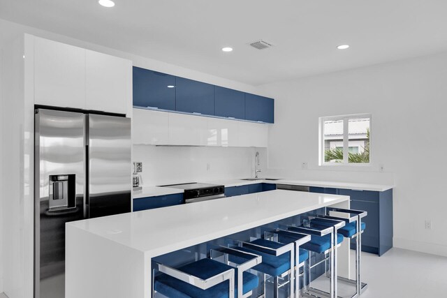 kitchen featuring white cabinetry, a center island, stainless steel fridge with ice dispenser, and a breakfast bar area