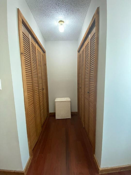 880 La Paloma Rd, Key Largo, FL 33037 - hall featuring wood finished floors, a textured ceiling, and baseboards