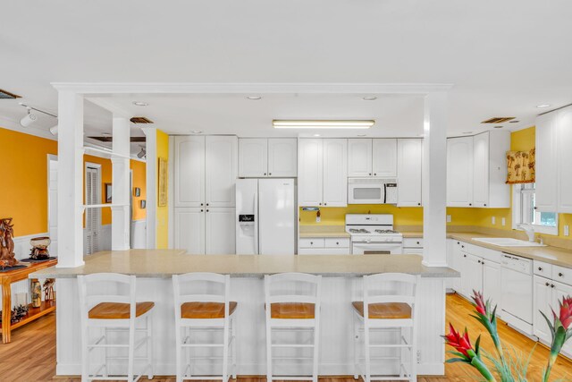 17166 W Wahoo Ln, Sugarloaf, FL 33042 - kitchen with white appliances, white cabinetry, a kitchen breakfast bar, and light countertops