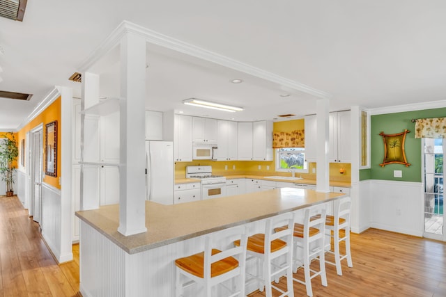 17166 W Wahoo Ln, Sugarloaf, FL 33042 - kitchen featuring white appliances, plenty of natural light, wainscoting, light wood-style flooring, and crown molding