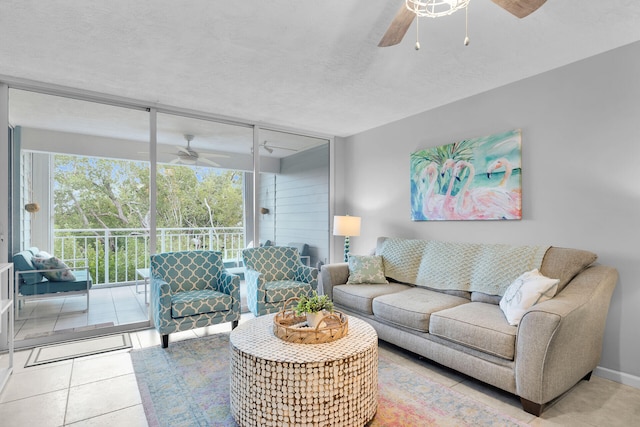 living room featuring ceiling fan, floor to ceiling windows, tile patterned flooring, and a textured ceiling