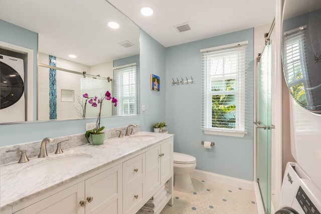 532 Porter Ln, Key West, FL 33040 - bathroom featuring stacked washer and clothes dryer, baseboards, a shower, toilet, and double vanity