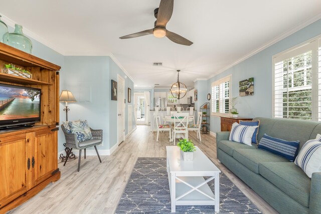 532 Porter Ln, Key West, FL 33040 - living room featuring light wood-style floors, crown molding, a ceiling fan, a chandelier, and baseboards