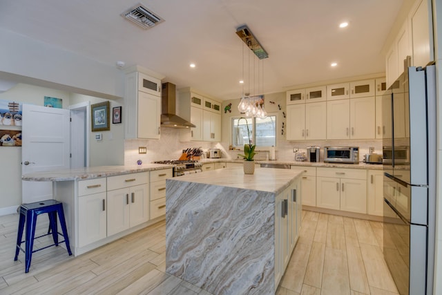 3034 Riviera Dr, Key West, FL 33040 - kitchen featuring a peninsula, wall chimney range hood, white cabinets, visible vents, and appliances with stainless steel finishes