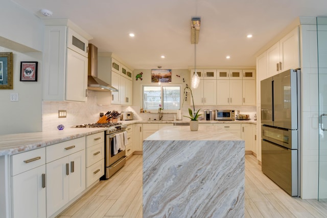 3034 Riviera Dr, Key West, FL 33040 - kitchen with wall chimney exhaust hood, light stone countertops, white cabinets, stainless steel appliances, and decorative backsplash