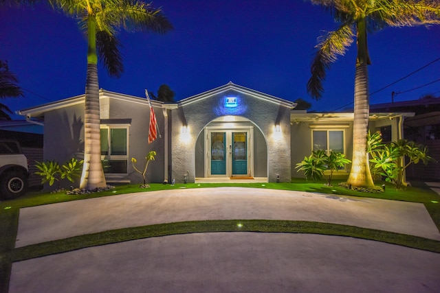 3034 Riviera Dr, Key West, FL 33040 - view of front of home with a lawn, french doors, stucco siding, and curved driveway