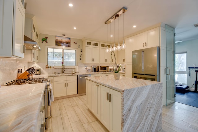 3034 Riviera Dr, Key West, FL 33040 - kitchen featuring tasteful backsplash, glass insert cabinets, stainless steel appliances, a kitchen island, and light stone counters