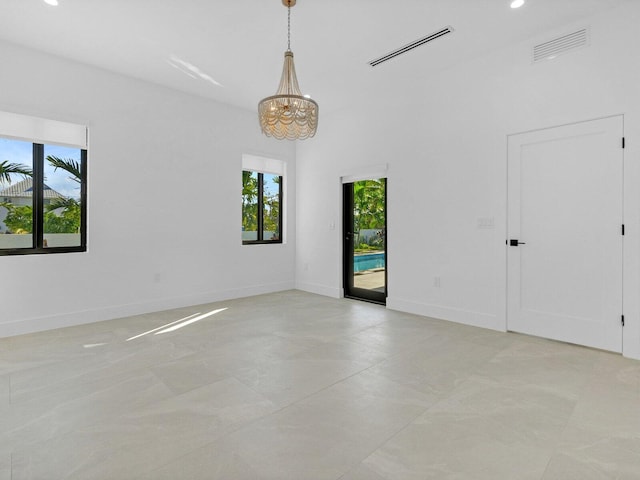 unfurnished room featuring a notable chandelier