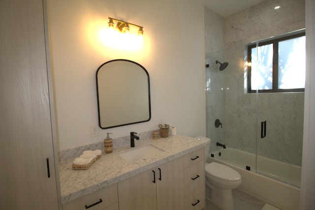 full bathroom with vanity, shower / bath combination with glass door, and toilet