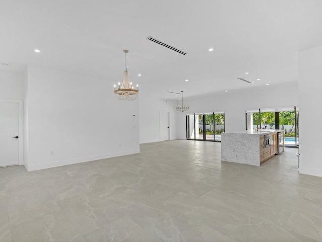 unfurnished living room featuring wine cooler and a notable chandelier