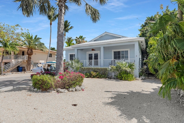 241 W Seaview Dr, Duck, FL 33050 - view of front facade with covered porch, stairs, stucco siding, and french doors