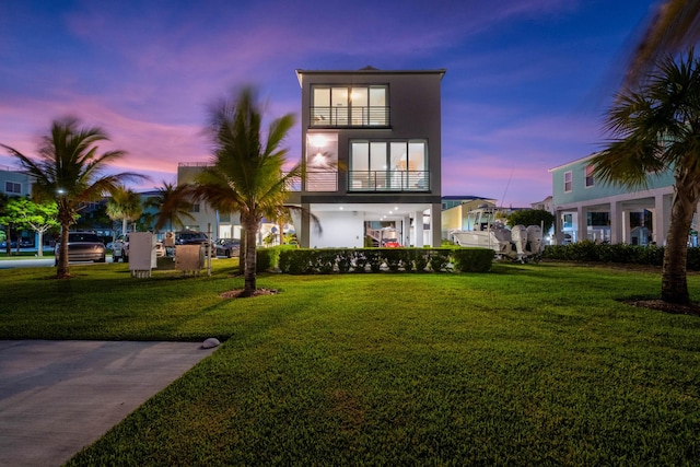 94825 Overseas Hwy Unit 204, Key Largo, FL 33037 - view of front facade with stucco siding, a balcony, and a front lawn