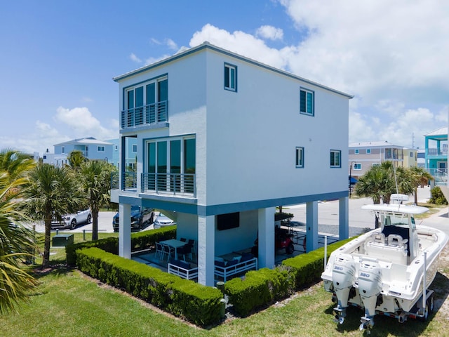 94825 Overseas Hwy Unit 204, Key Largo, FL 33037 - view of side of property featuring stucco siding, a carport, and a balcony