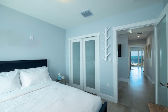 94825 Overseas Hwy Unit 204, Key Largo, FL 33037 - bedroom featuring baseboards, a closet, and finished concrete floors