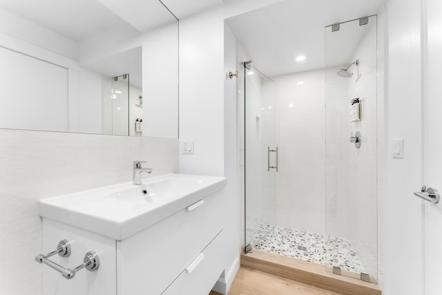 bathroom with vanity, decorative backsplash, and a shower with shower door