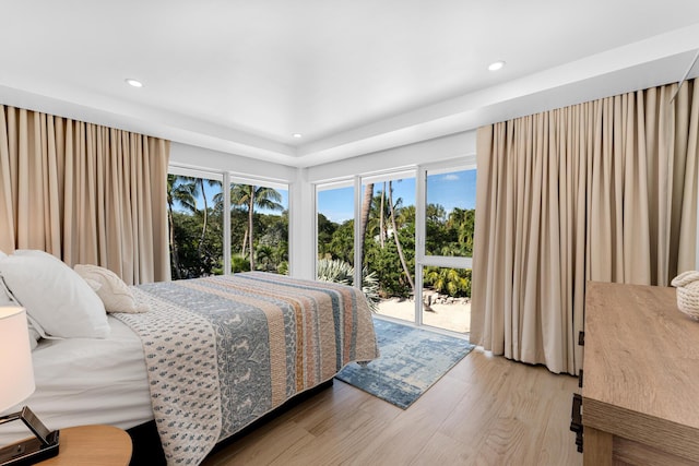 bedroom featuring wood-type flooring and access to outside