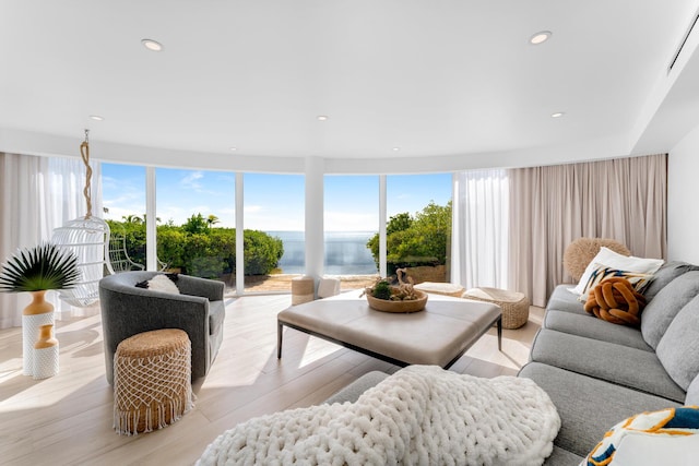 living room with a water view and light hardwood / wood-style flooring