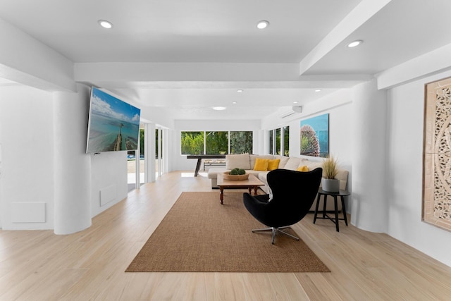 living room featuring a wall mounted AC and light hardwood / wood-style flooring