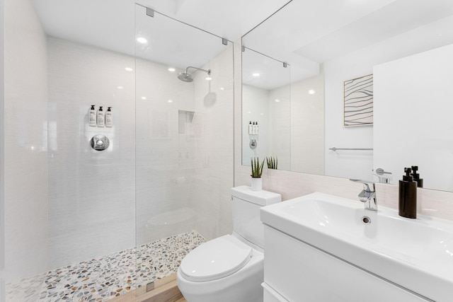 bathroom featuring tiled shower, vanity, and toilet