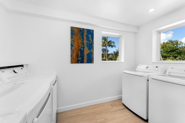 laundry area with light wood-type flooring and independent washer and dryer