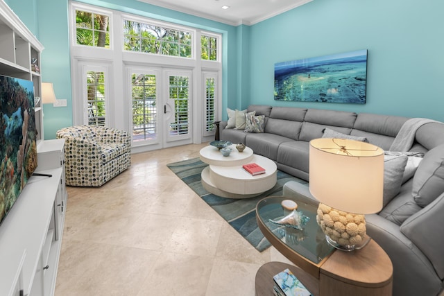 living area featuring a healthy amount of sunlight, a towering ceiling, crown molding, and french doors