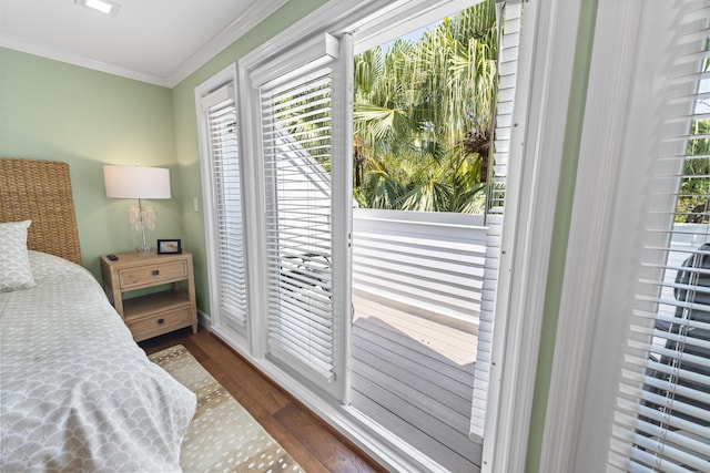 bedroom featuring access to outside, crown molding, and wood finished floors