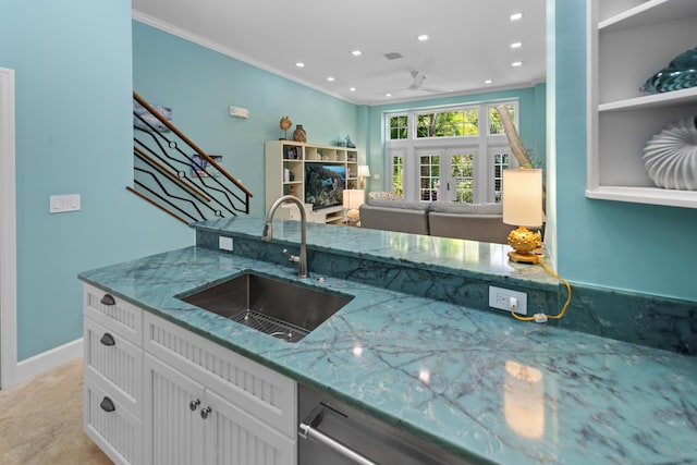 kitchen with stone counters, crown molding, visible vents, white cabinetry, and a sink