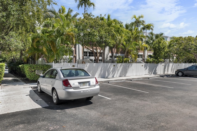 uncovered parking lot featuring fence