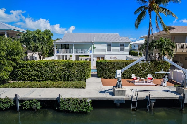 back of house with a patio, a balcony, and a water view