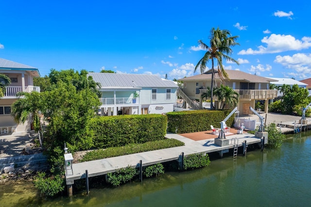 rear view of house featuring a balcony and a water view