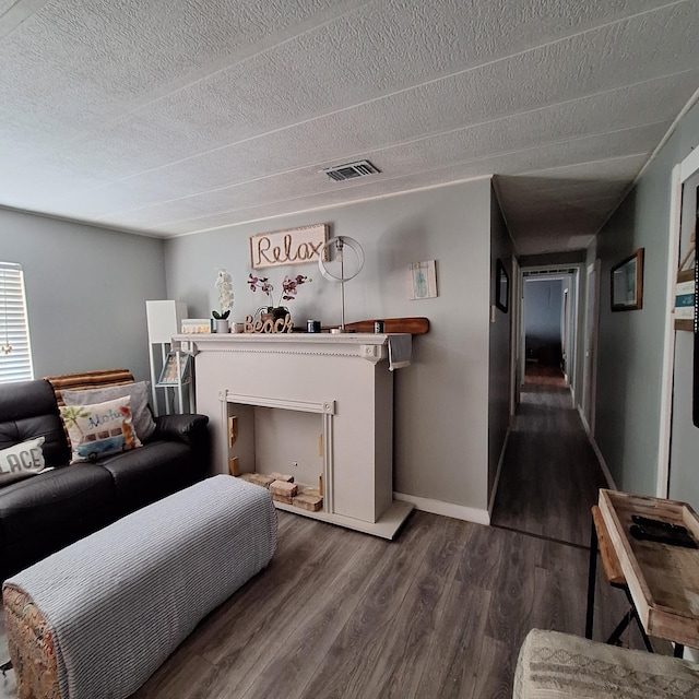 living room featuring dark hardwood / wood-style flooring and a textured ceiling