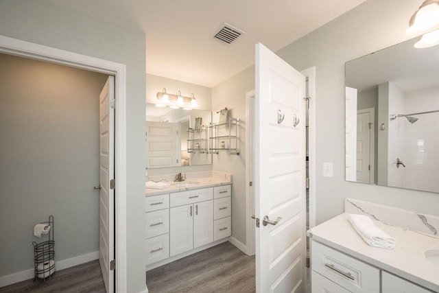 bathroom featuring vanity, wood-type flooring, and walk in shower