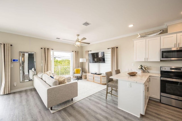 living room featuring ornamental molding, light hardwood / wood-style floors, and ceiling fan