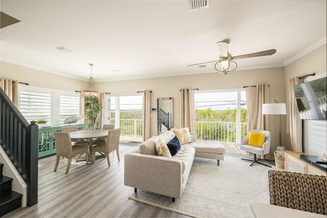 living room with crown molding, ceiling fan, and light hardwood / wood-style flooring