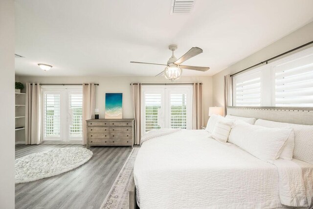 bedroom featuring multiple windows, hardwood / wood-style flooring, and ceiling fan