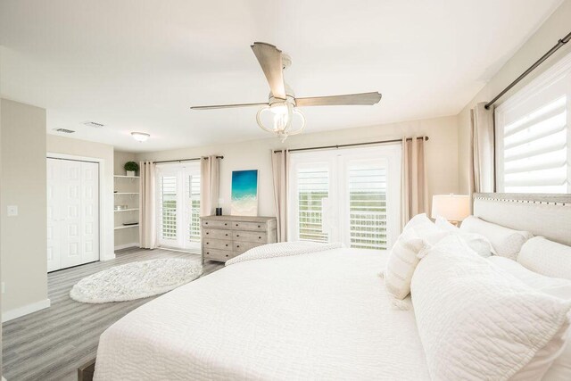 bedroom with access to exterior, wood-type flooring, and ceiling fan