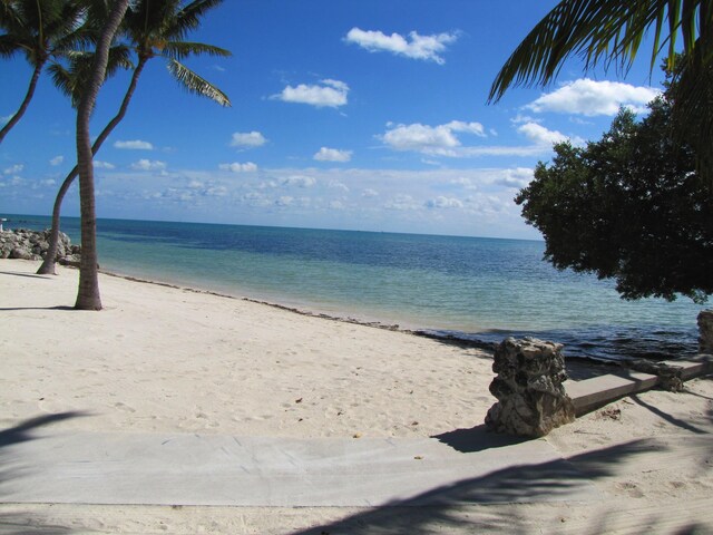 bird's eye view featuring a water view and a beach view