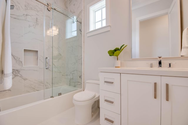 full bathroom with vanity, toilet, and combined bath / shower with glass door