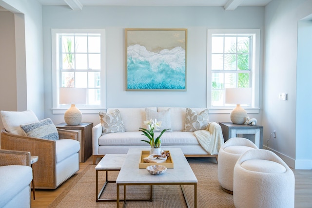 living room featuring beamed ceiling and light wood-type flooring