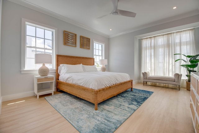 bedroom with ceiling fan, ornamental molding, and light hardwood / wood-style flooring